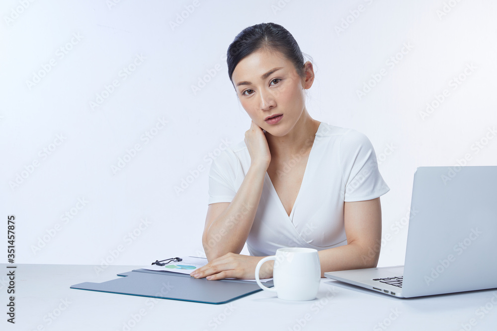 Concept businesswoman. Photo of successful asian woman sitting at table and working with documents and laptop, isolated over white background in studio. Concept businesswoman. Photo of successful asian woman sitting at table and working with documents and laptop, isolated over white background in studio.