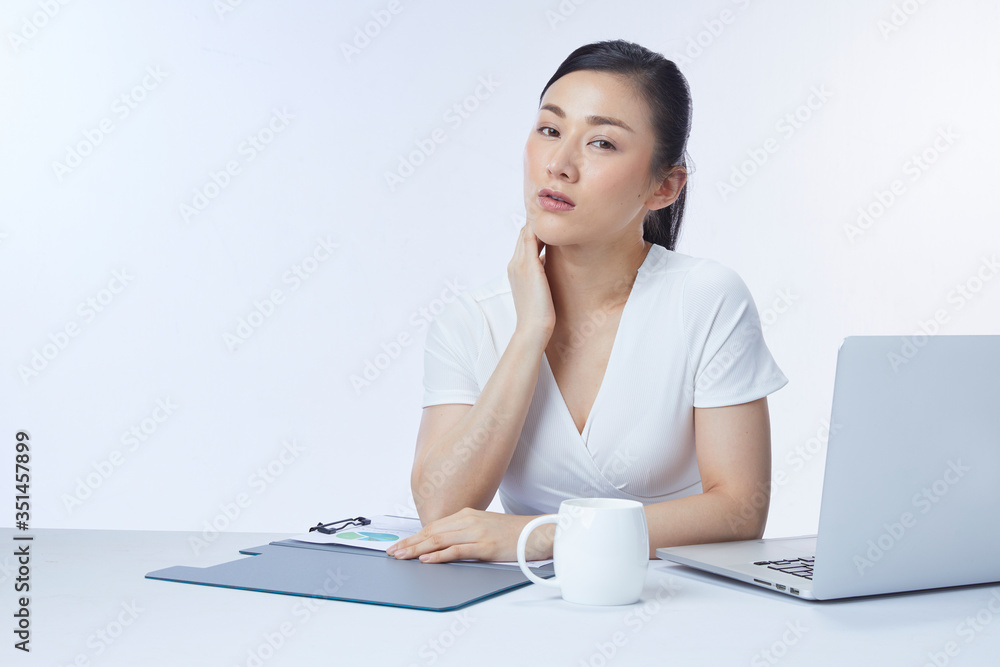 Concept businesswoman. Photo of successful asian woman sitting at table and working with documents and laptop, isolated over white background in studio. Concept businesswoman. Photo of successful asian woman sitting at table and working with documents and laptop, isolated over white background in studio.