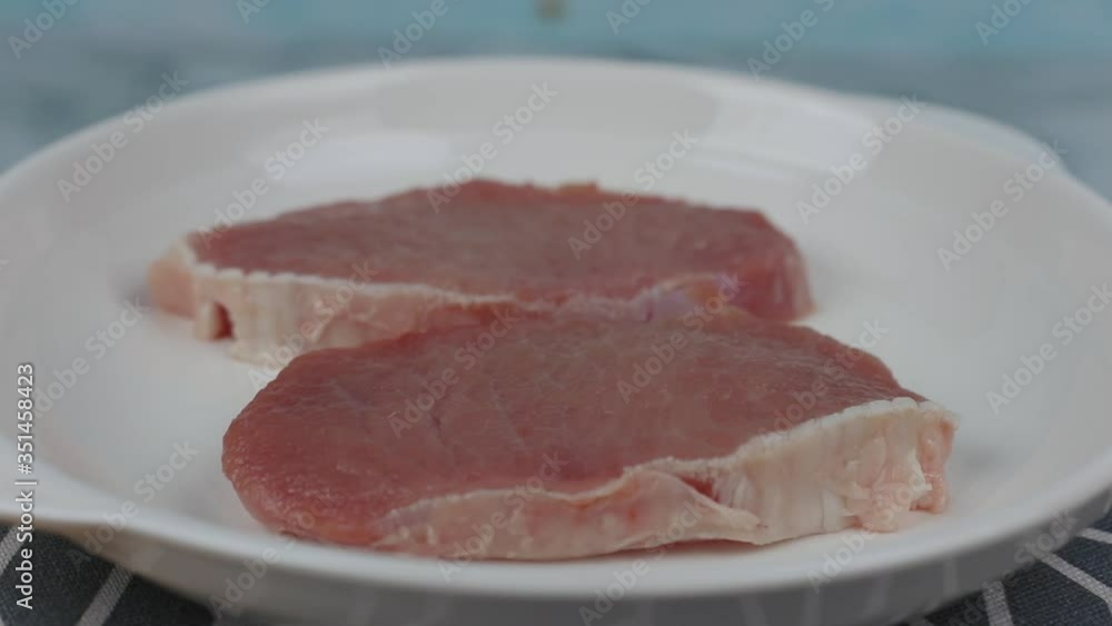 Pork Meat , pork , slices pork loin in a white plate rotating Pork Meat , pork , slices pork loin in a white plate rotating
