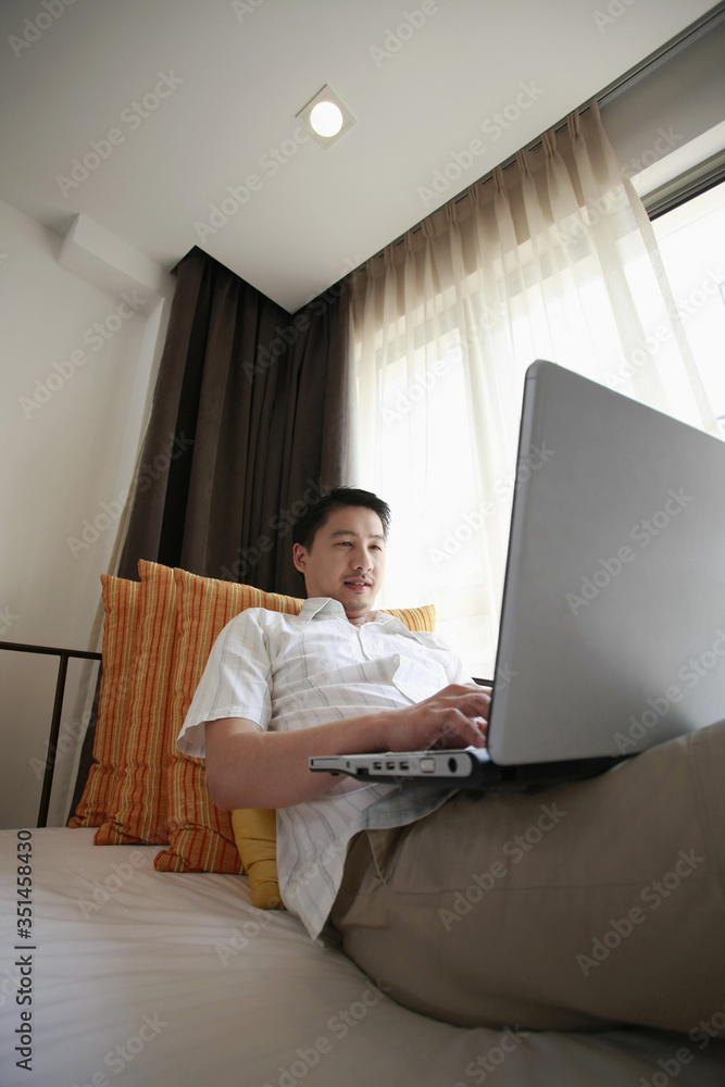 Man using laptop in the hotel room Man using laptop in the hotel room
