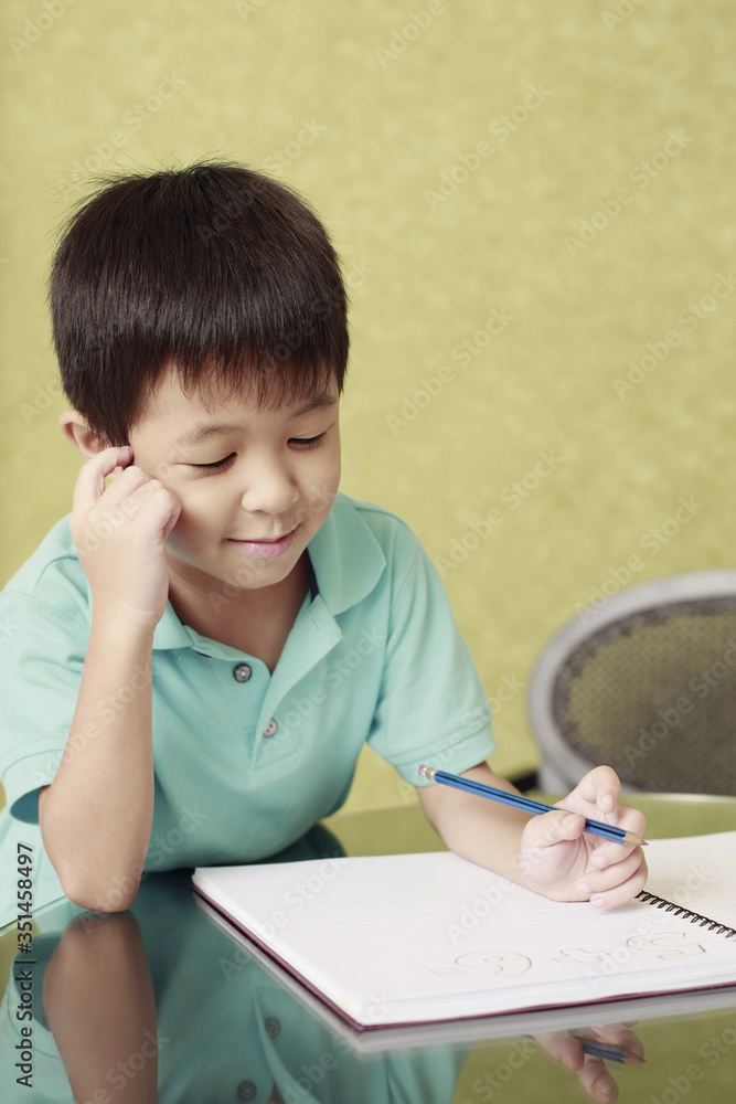 Boy thinking while doing homework Boy thinking while doing homework