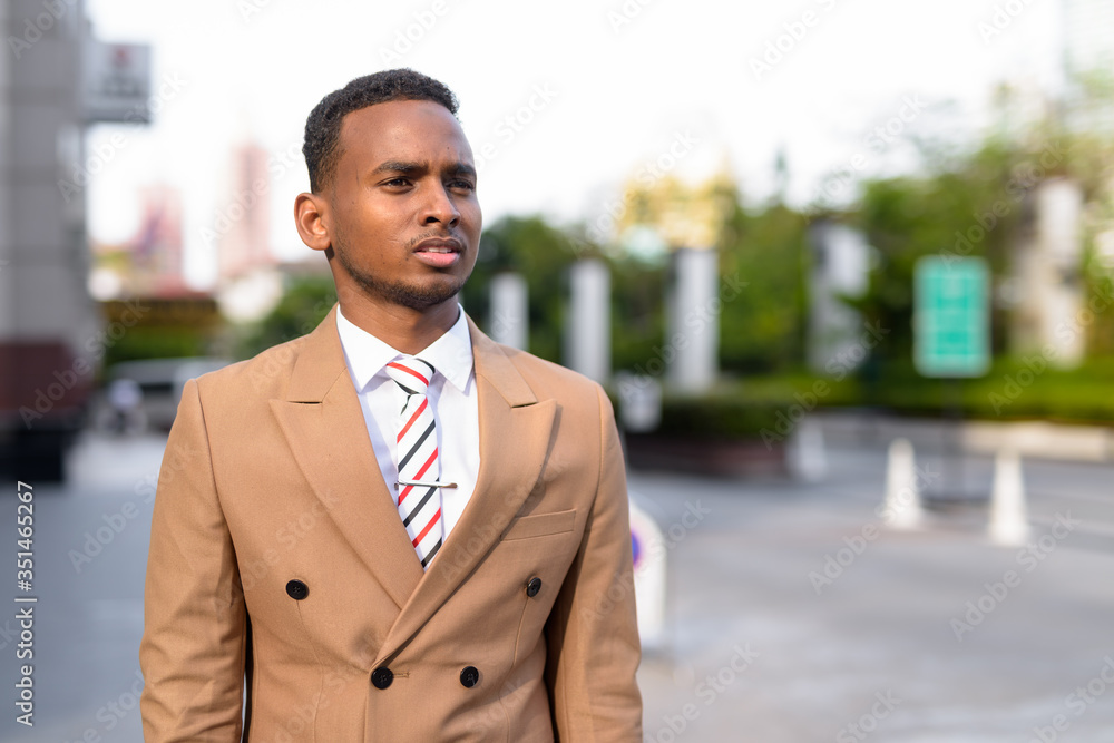 Young handsome African businessman thinking in the streets outdoors Young handsome African businessman thinking in the streets outdoors