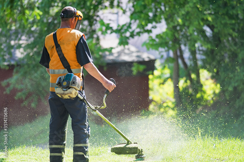 worker cutting grass