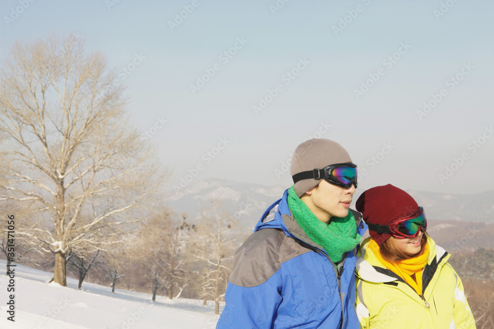 Man and woman with ski goggles looking away Man and woman with ski goggles looking away
