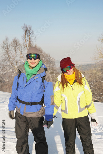 Man and woman with ski wear and backpacks