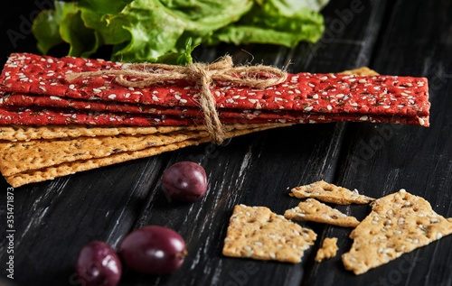 Beetroot and rye flour crackers with vegetables for making snacks on a black background. Vegetarianism and healthy eating