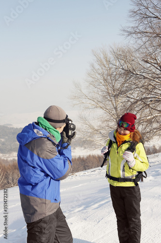 Man taking picture of woman on winter day