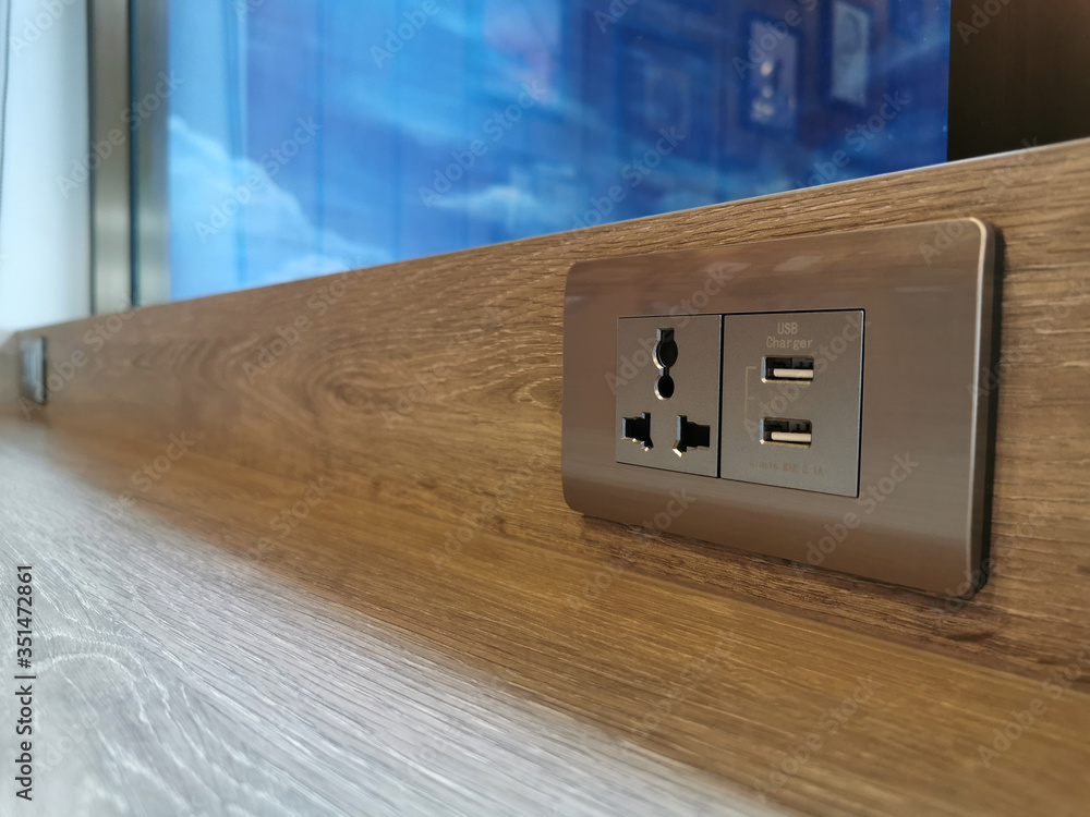 Silver color electrical wall socket adapter, Three-plug power outlet and  two universal USB charger socket on the wooden table in the coffee shop.  foto de Stock | Adobe Stock
