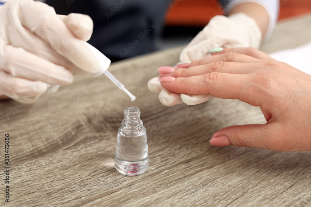 Manicure master working with female client in beauty salon, closeup Manicure master working with female client in beauty salon, closeup