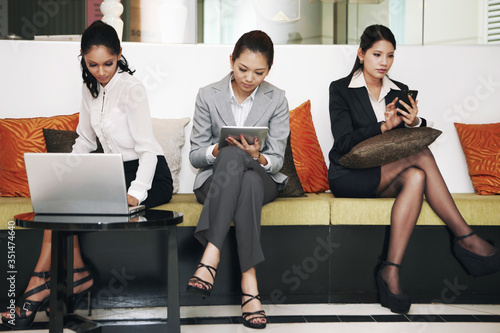 Foto Businesswomen using electronic devices