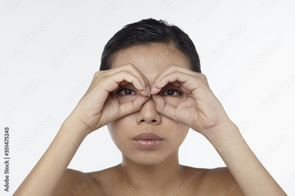 Woman looking through her hands as binoculars