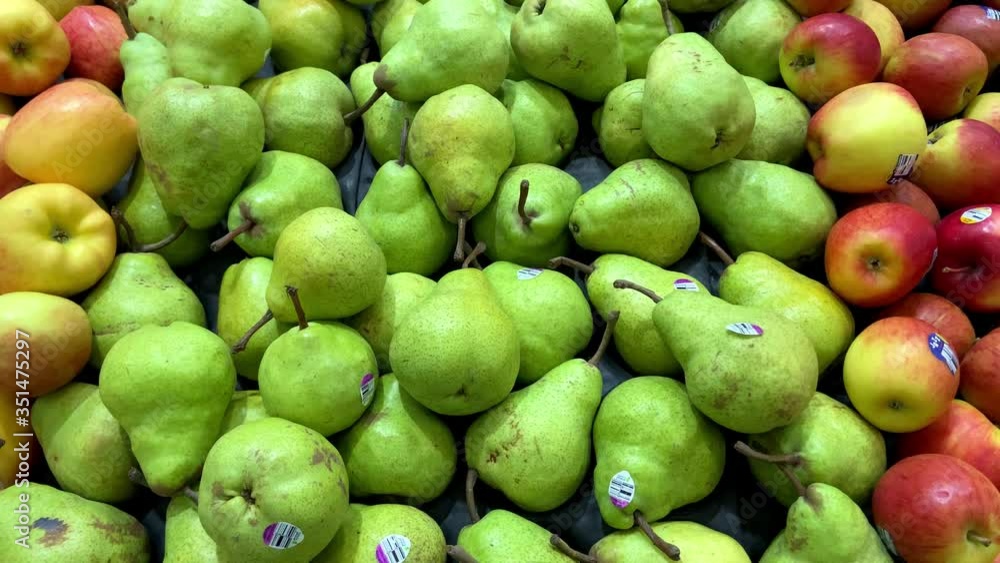 Fresh whole Green Packham Pear, ripe and juicy between the apples, close up