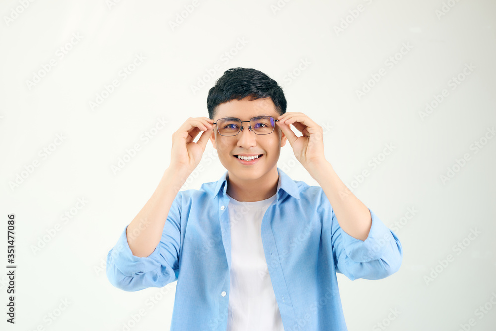 Closeup of friendly guy wearing eyeglasses. Young asian man adjusting glasses and staring at camera through lens. Vision and eye care concept Closeup of friendly guy wearing eyeglasses. Young asian man adjusting glasses and staring at camera through lens. Vision and eye care concept