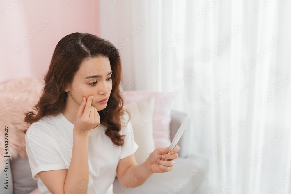 asian woman look mirror with acne problem at home asian woman look mirror with acne problem at home