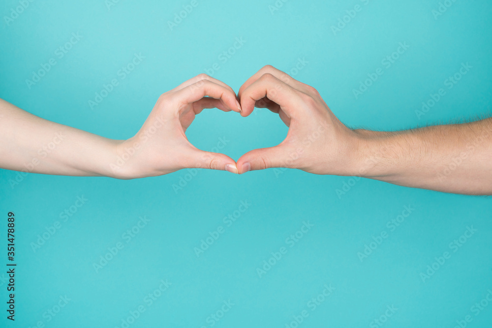 Obraz premium Cropped close-up photo of woman and man making heart with their hands isolated on blue teal bright color background