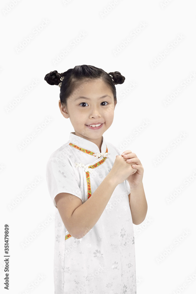 Girl in cheongsam smiling with greeting hand gesture Girl in cheongsam smiling with greeting hand gesture