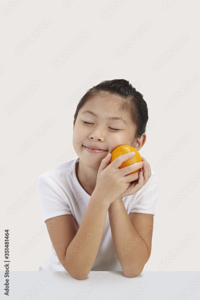 Girl smiling and holding an orange Girl smiling and holding an orange