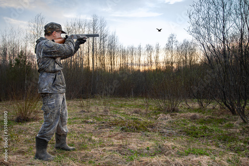 Obraz na płótnie a hunter shoots a low flying woodcock in the evening