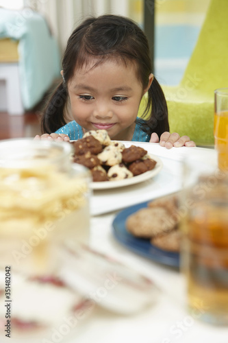 Girl smiling while looking at a plate of cookies