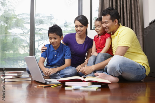 Family using laptop together © ImageHit