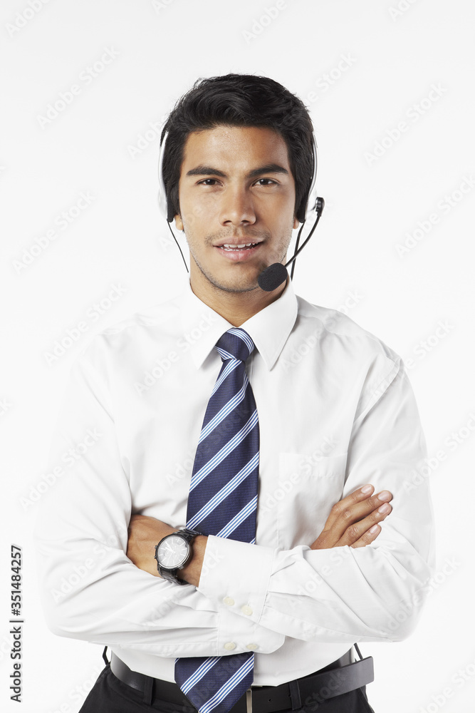 Young businessman wearing headset with arms crossed Young businessman wearing headset with arms crossed