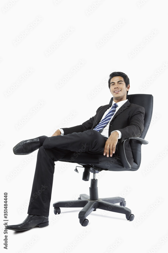Confident young businessman seated in an office chair Confident young businessman seated in an office chair