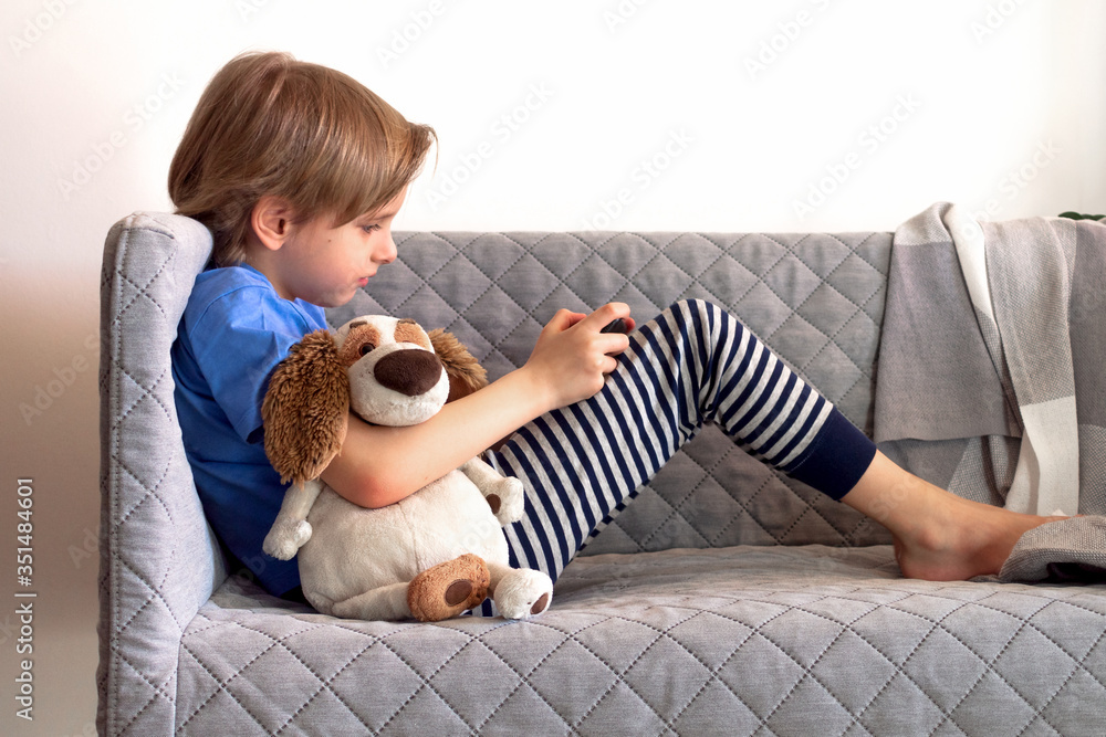 Distance learning online education and work. Child study remotely from home on the couch. Boy hands hold mobile phone Distance learning online education and work. Child study remotely from home on the couch. Boy hands hold mobile phone