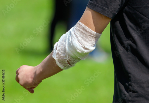 A wounded man’s arm wrapped in a bandage