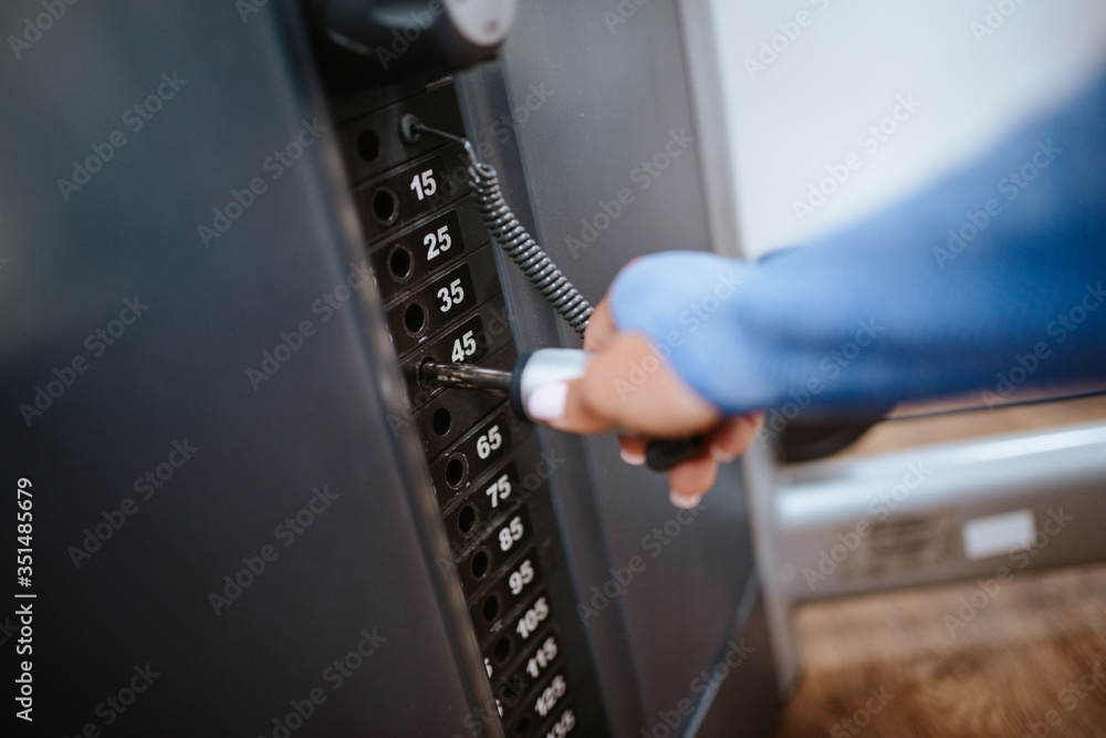 Naklejka premium Close up of a young caucasian girl's hand while setting up a device in the gym