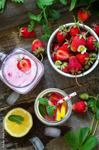 Healthy dieting concept. Lemonade with fresh strawberries and Strawberry fruit Yogurt smoothie or milk shake on a rustic wooden table. Top view flat lay background.