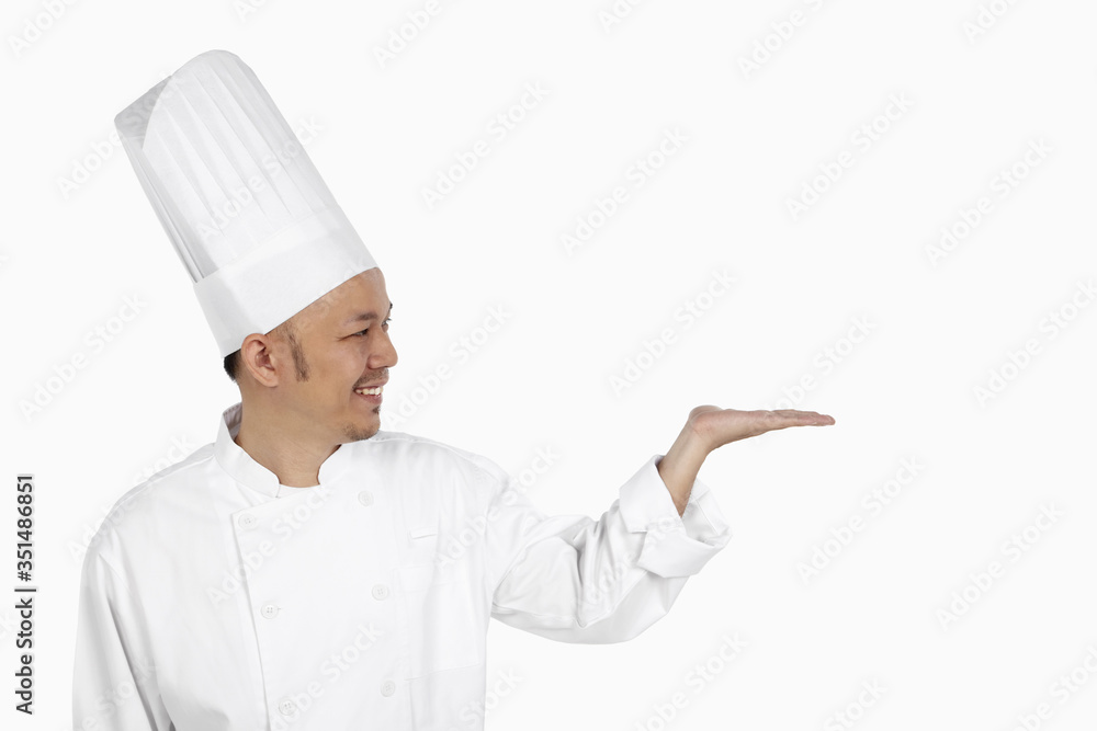 Asian chef gesturing with opened palm Asian chef gesturing with opened palm