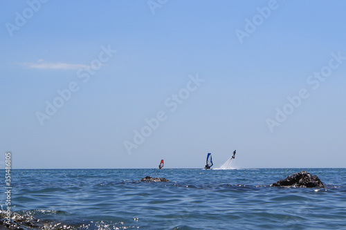 Walk on the sea on a board with a sail. Flying on a water jet.