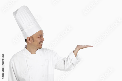 Asian chef gesturing with opened palm