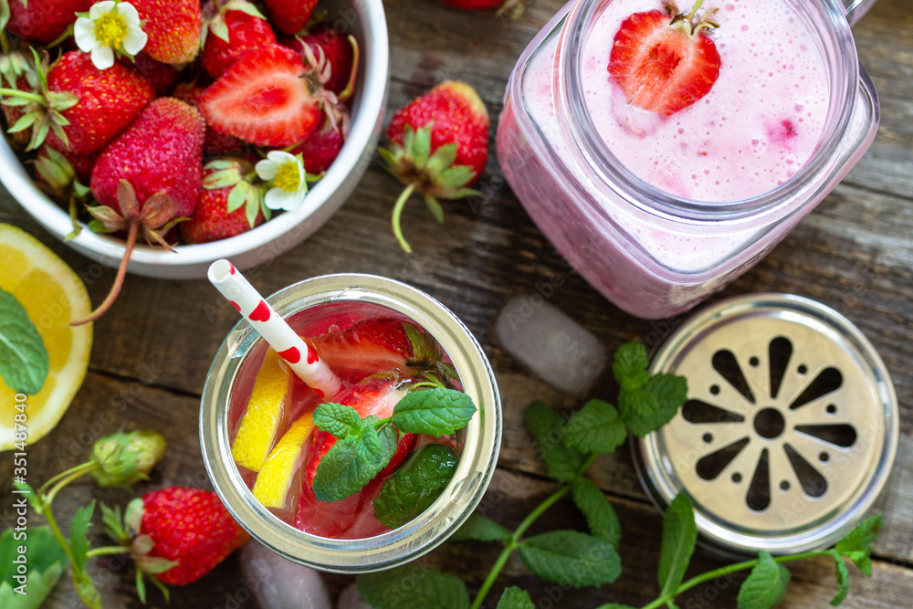 Healthy dieting concept. Lemonade with fresh strawberries and Strawberry fruit Yogurt smoothie or milk shake on a rustic wooden table. Top view flat lay background. Healthy dieting concept. Lemonade with fresh strawberries and Strawberry fruit Yogurt smoothie or milk shake on a rustic wooden table. Top view flat lay background.