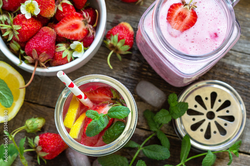 Healthy dieting concept. Lemonade with fresh strawberries and Strawberry fruit Yogurt smoothie or milk shake on a rustic wooden table. Top view flat lay background.