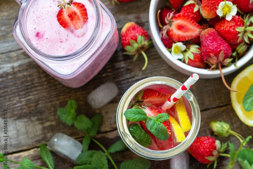 Healthy dieting concept. Lemonade with fresh strawberries and Strawberry fruit Yogurt smoothie or milk shake on a rustic wooden table. Top view flat lay background. Copy space. Healthy dieting concept. Lemonade with fresh strawberries and Strawberry fruit Yogurt smoothie or milk shake on a rustic wooden table. Top view flat lay background. Copy space.