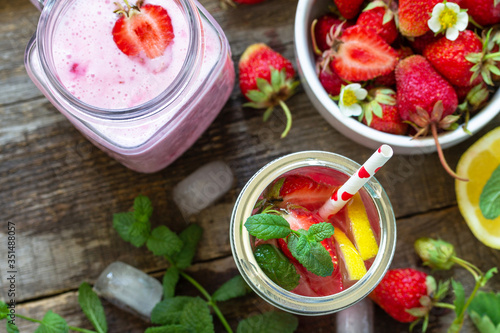 Healthy dieting concept. Lemonade with fresh strawberries and Strawberry fruit Yogurt smoothie or milk shake on a rustic wooden table. Top view flat lay background. Copy space.