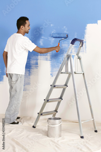 Man painting wall with roller © ImageHit