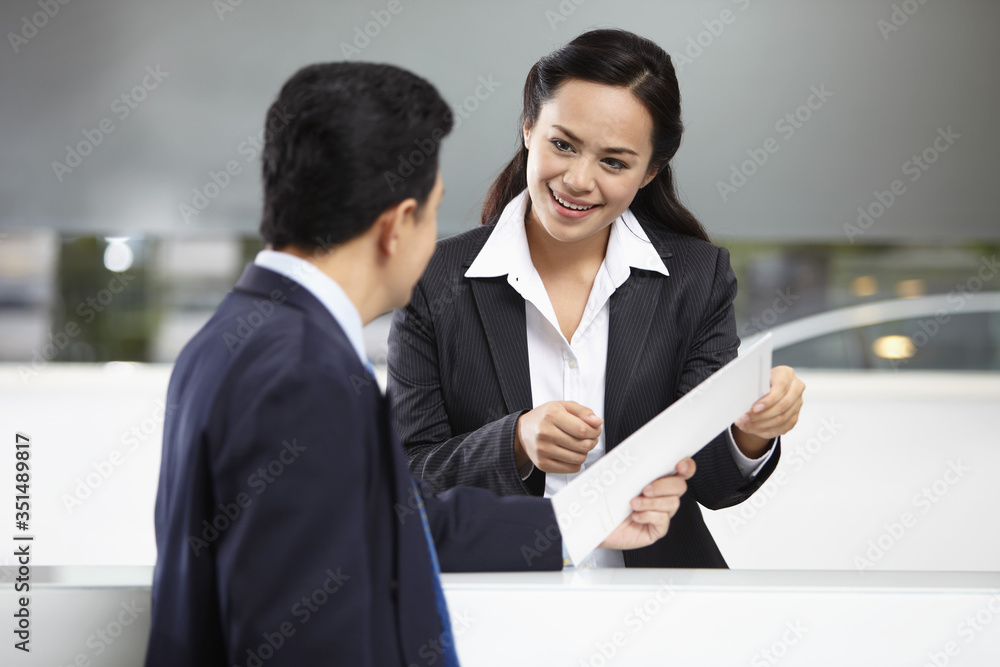 Sales representative interacting with a customer at the counter Sales representative interacting with a customer at the counter