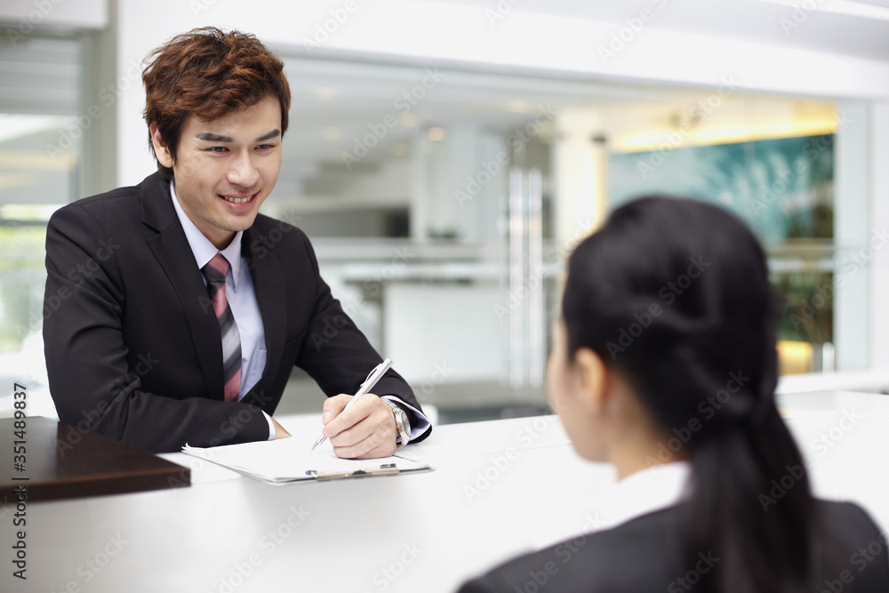 Sales representative interacting with a customer at the counter Sales representative interacting with a customer at the counter
