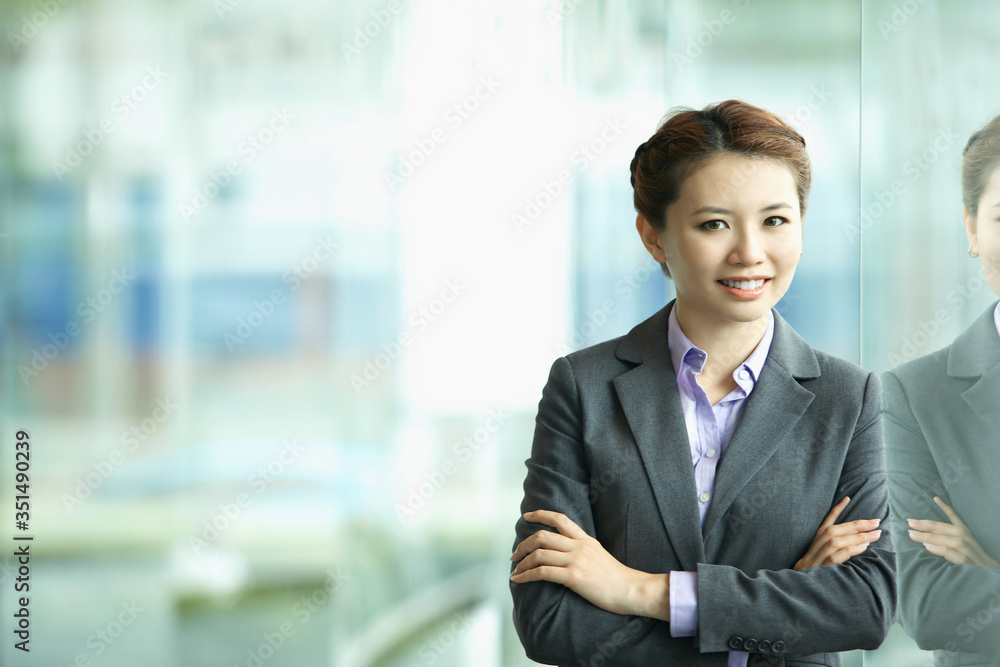 Businesswoman smiling at the camera, arms crossed Businesswoman smiling at the camera, arms crossed