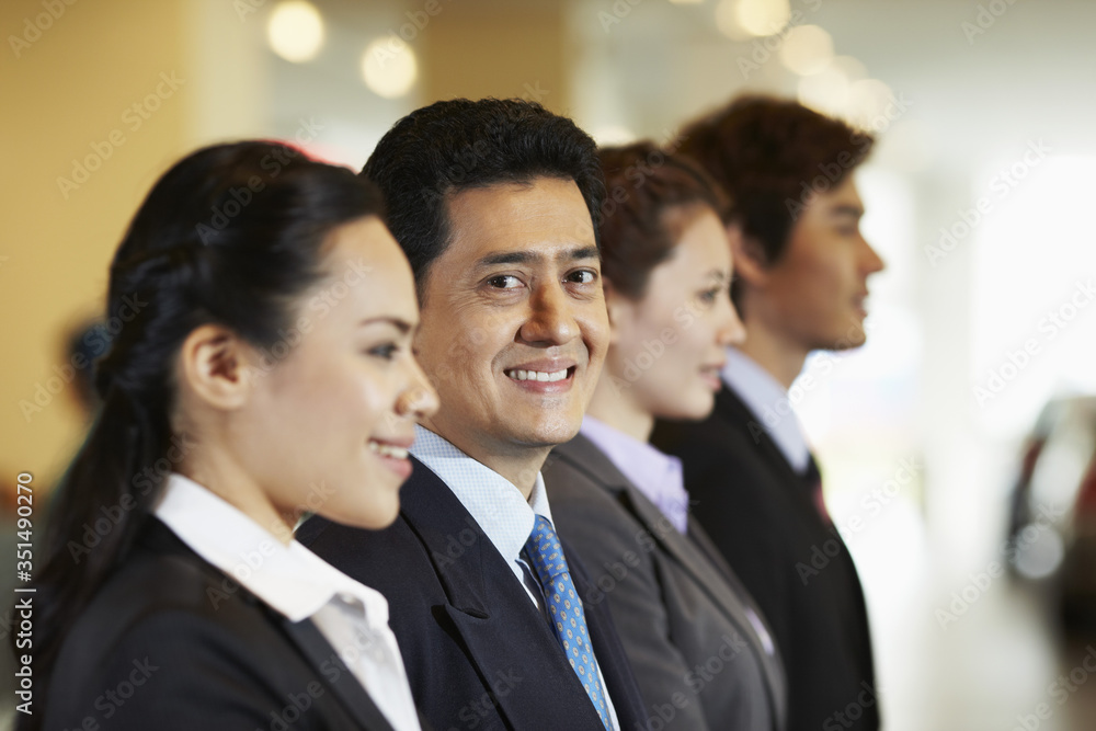 Business people standing in a row ready to greet clients Business people standing in a row ready to greet clients
