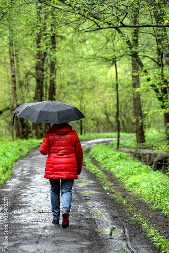 woman walks in the Park under an umbrella in the rain