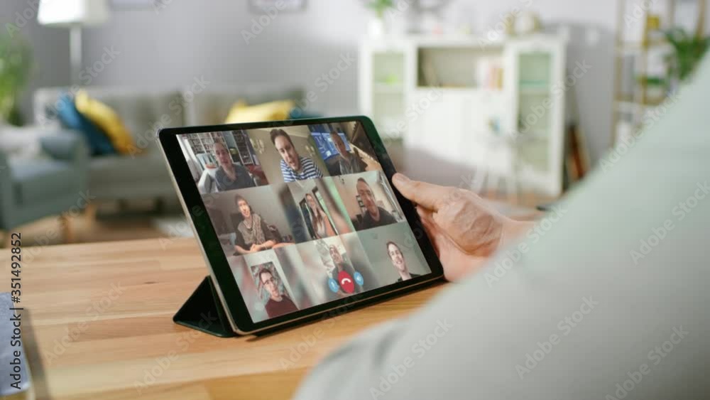 Home Office: Man Uses Digital Tablet Computer with Conference Video Call App to Chat With Friends, Relatives and Coworkers. Remote Work, Home Office, Staying in Touch with Friends and Family Home Office: Man Uses Digital Tablet Computer with Conference Video Call App to Chat With Friends, Relatives and Coworkers. Remote Work, Home Office, Staying in Touch with Friends and Family