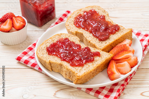 whole wheat bread with strawberry jam and fresh strawberry