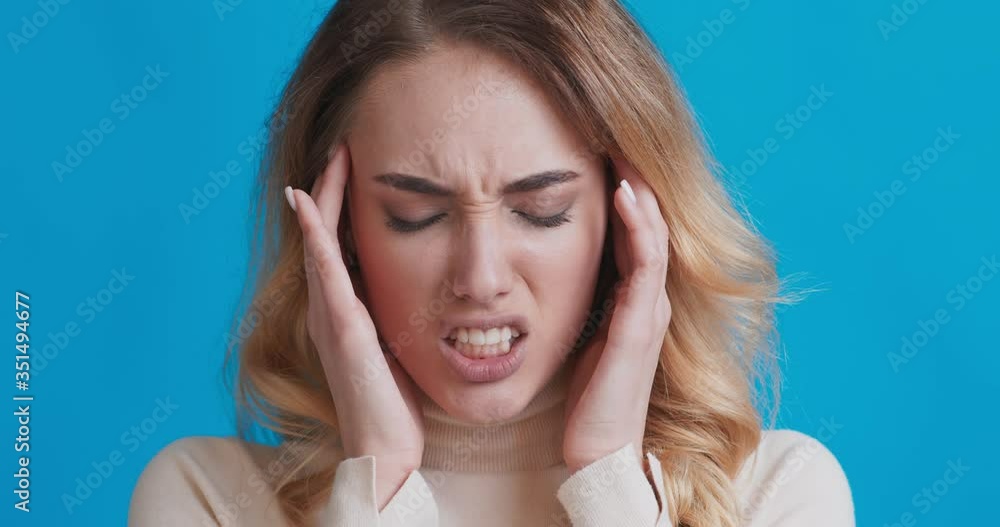 Suffering woman with headache touching her temples Suffering woman with headache touching her temples