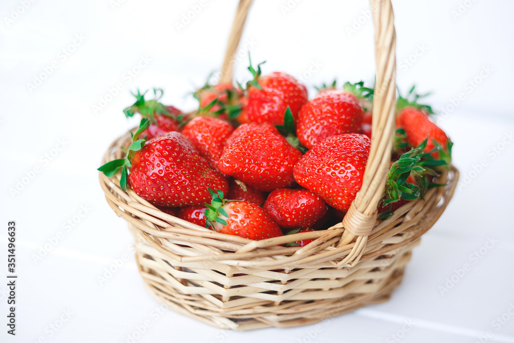 wicker basket with fresh strawberries on a wooden background wicker basket with fresh strawberries on a wooden background