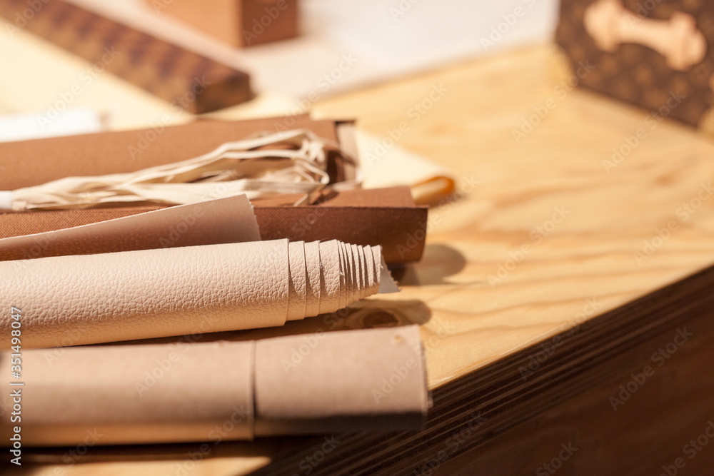 Rolls of natural beige leather. Materials for leather craft on the table
