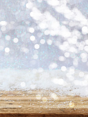 Christmas snowy bokeh background. Snowfall over a wooden table, xmas card template