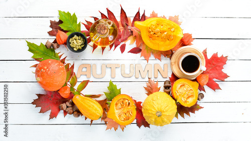 Autumn background with coffee  pumpkin  autumn leaves. flat lay. On a white wooden background. Top view. Free space for your text.